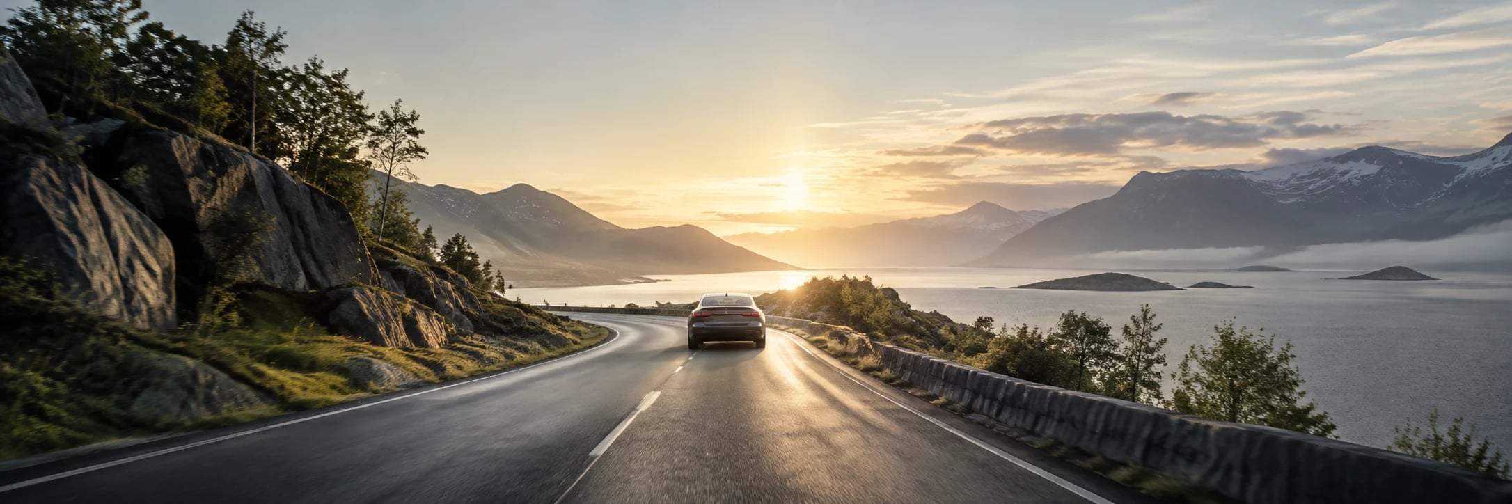 Kelias ir automobilis šiltoje ryto šviesoje, atviro horizonto link